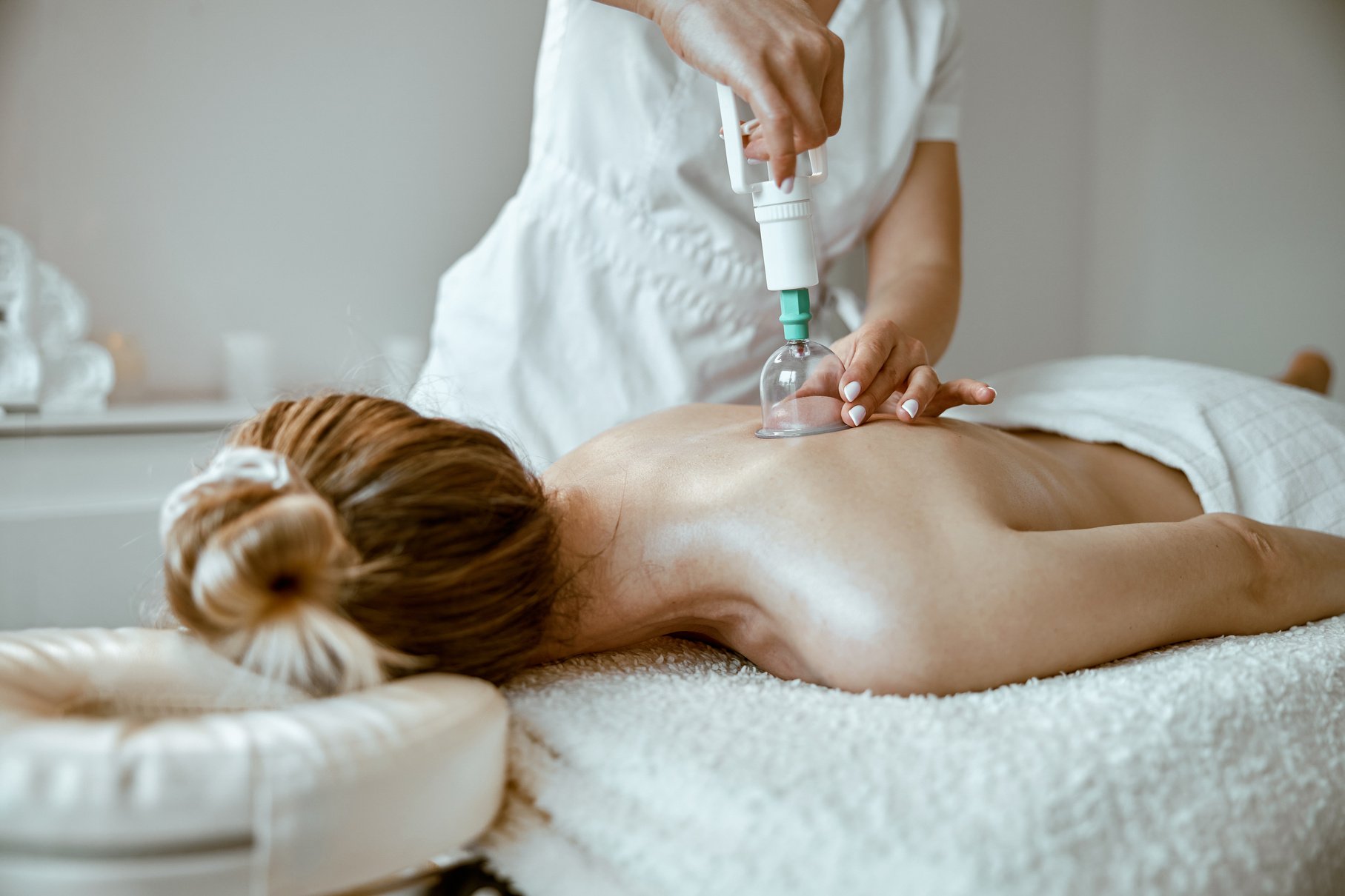 Professional Female Specialist Is Doing Cupping  on the Back of Beautiful Caucasian Lady